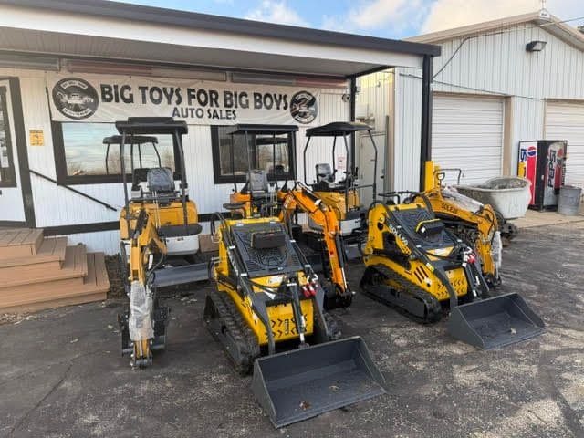 Construction equipment for sale at Big Toys for Big Boys auto sales, featuring small excavators and loaders.