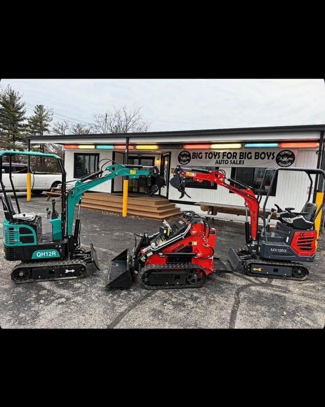 Three compact excavators in front of Big Toys for Big Boys auto sales, showcasing various models.