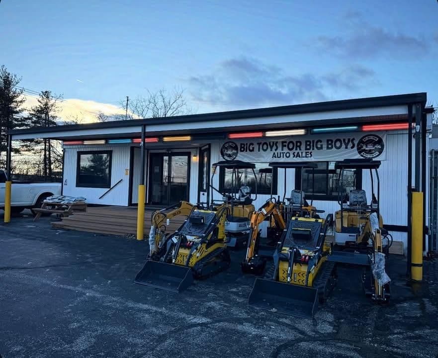 Auto sales dealership "Big Toys for Big Boys" featuring compact construction equipment.