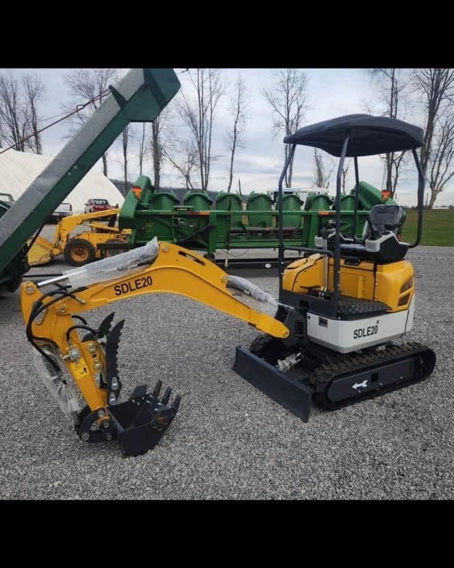 Compact SDLE20 excavator with bucket and tracks, set on gravel in an outdoor setting.