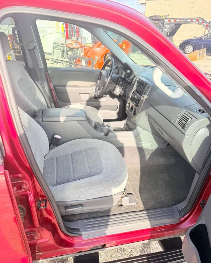 Interior view of a red SUV showing gray upholstered front seats and dashboard.