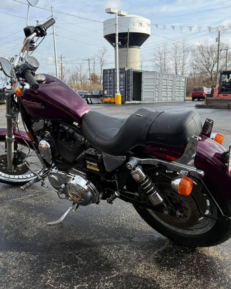 Harley-Davidson motorcycle in a parking lot with a water tower in the background.