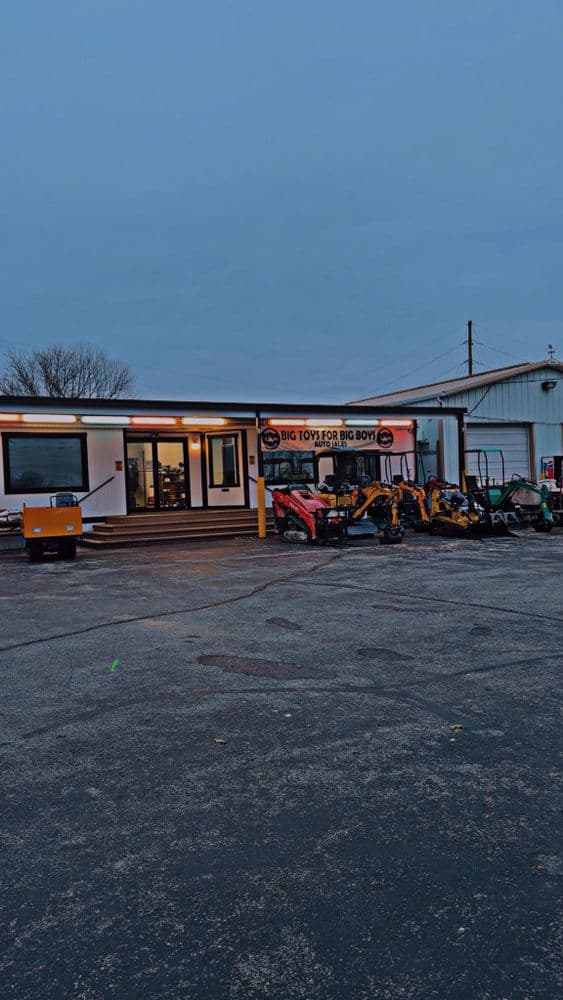 Big Toyzor Big Boys dealership featuring various tractors and outdoor equipment at dusk.