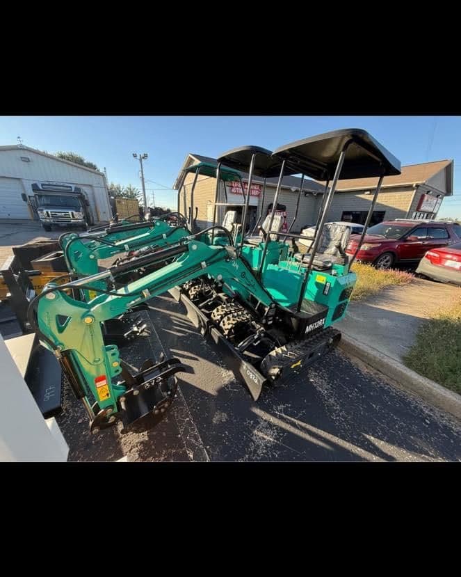 New compact excavator featuring dual front attachments, ready for construction use.